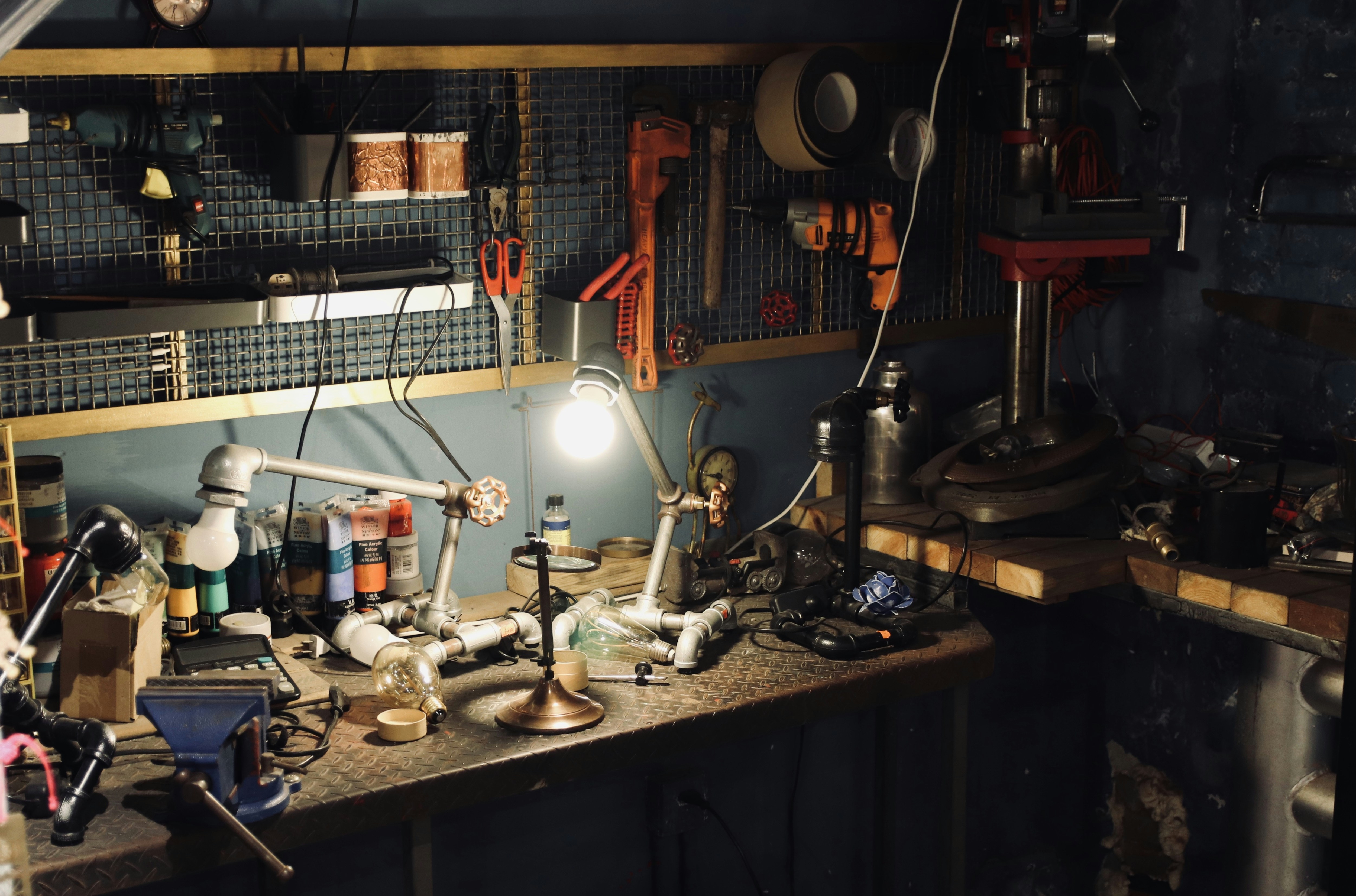A collection of high-quality workstation sink accessories, including a hardwood cutting board, a stainless steel colander, and a roll-up drying rack.