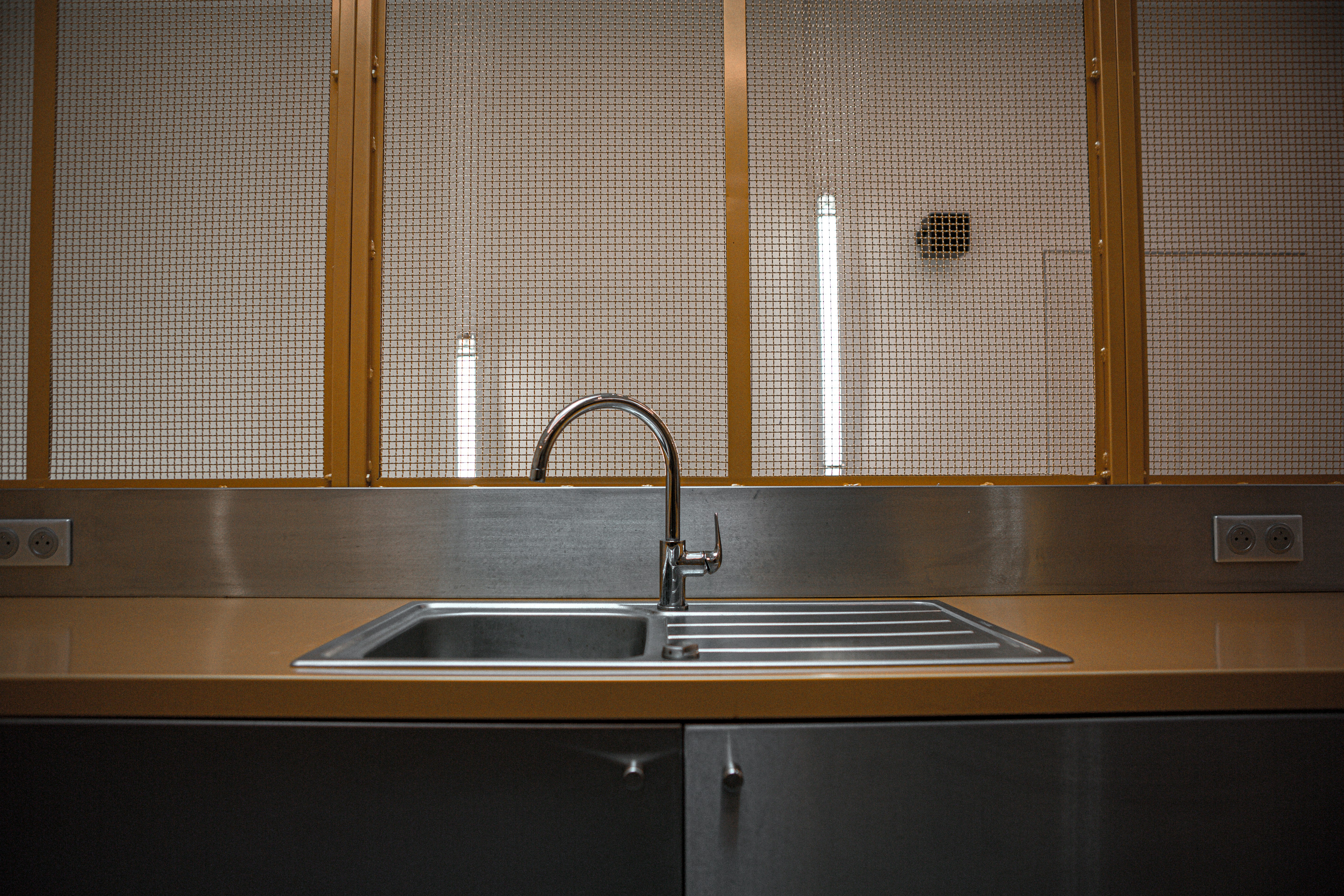 A modern stainless steel kitchen sink installed in a granite countertop