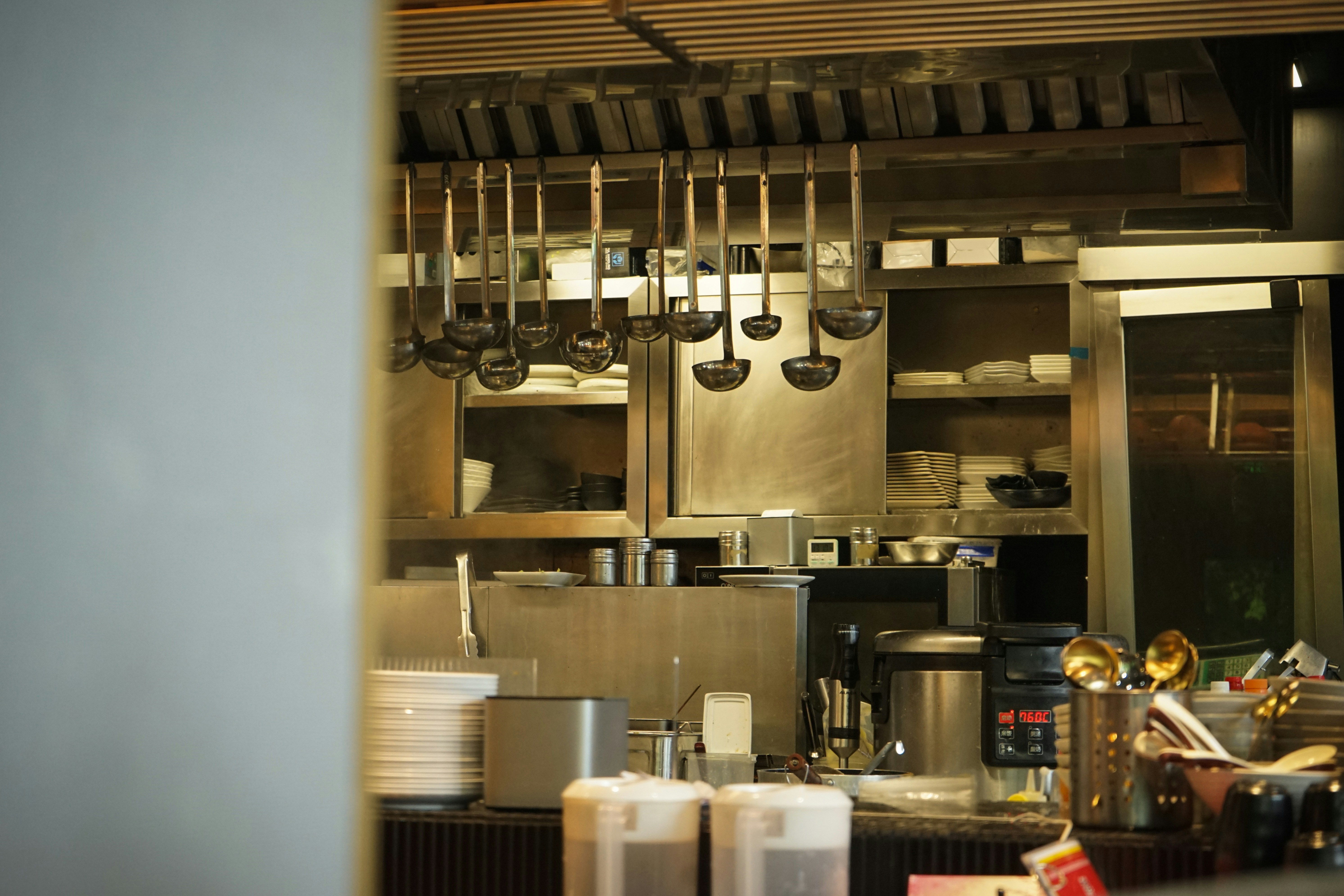 A compact stainless steel hand sink mounted on a wall in a commercial kitchen