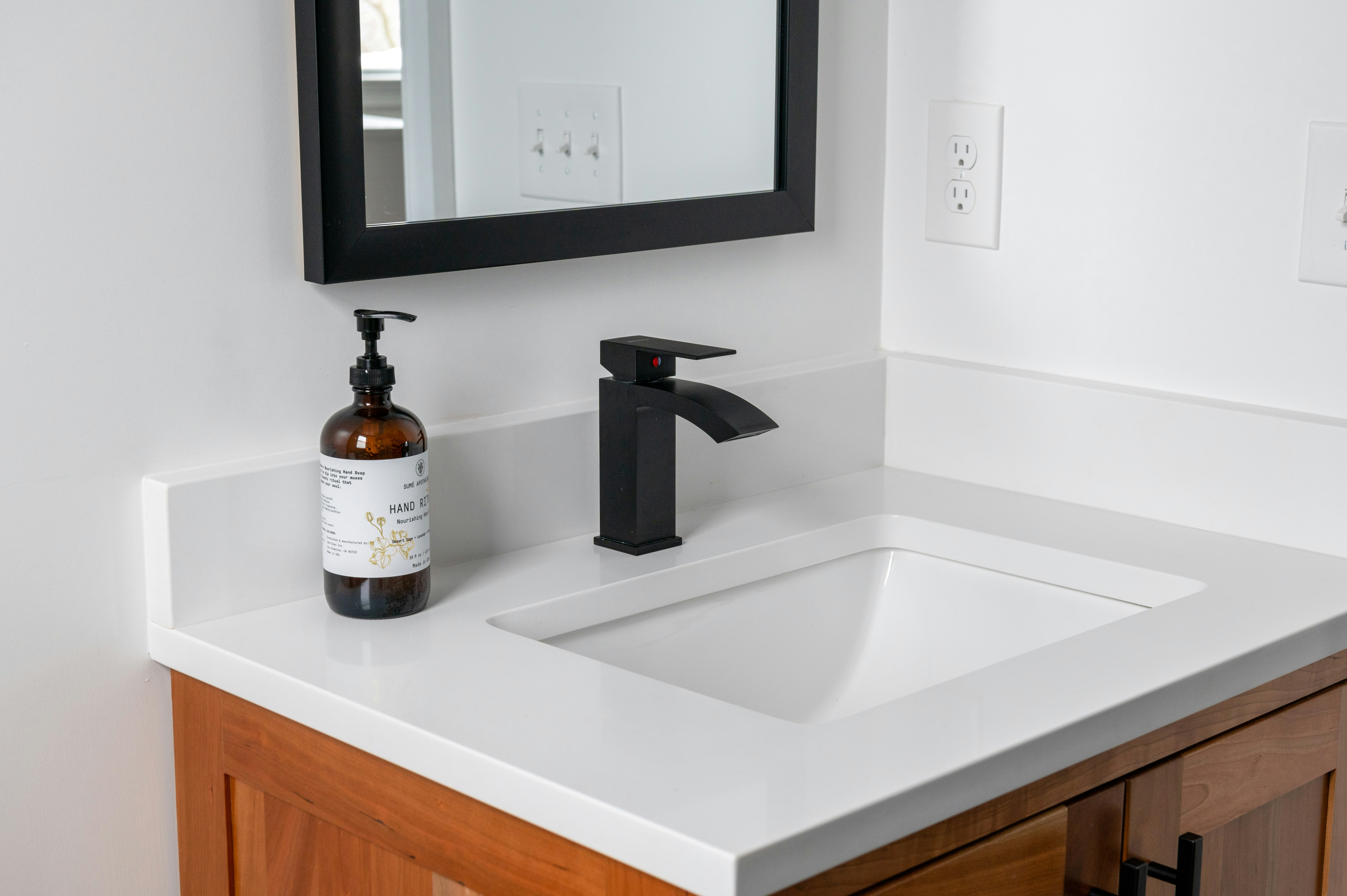 A wall-mounted stainless steel handwashing sink with a hands-free faucet, soap dispenser, and paper towel dispenser.