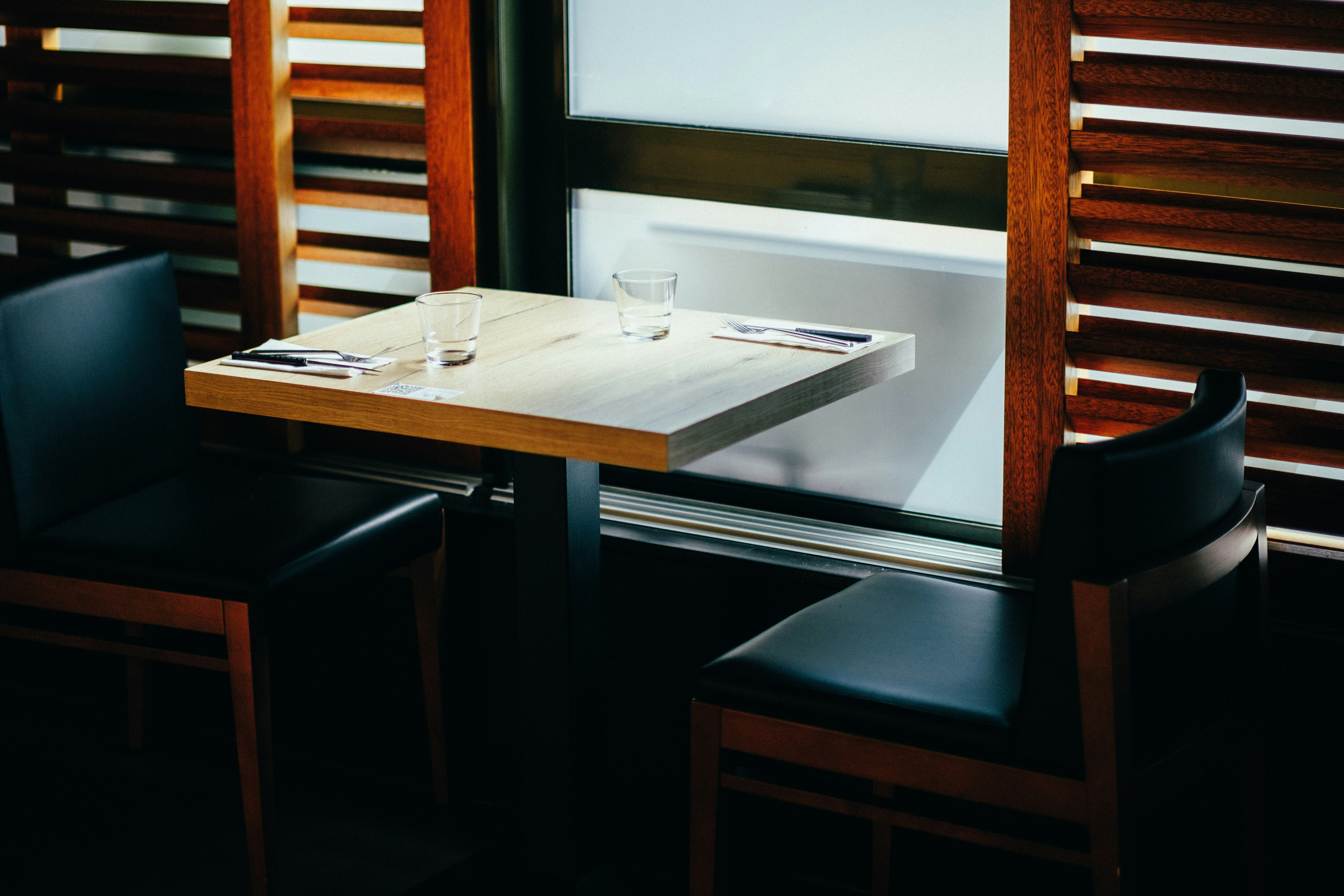 A gleaming three-compartment commercial stainless steel sink in a busy restaurant kitchen.