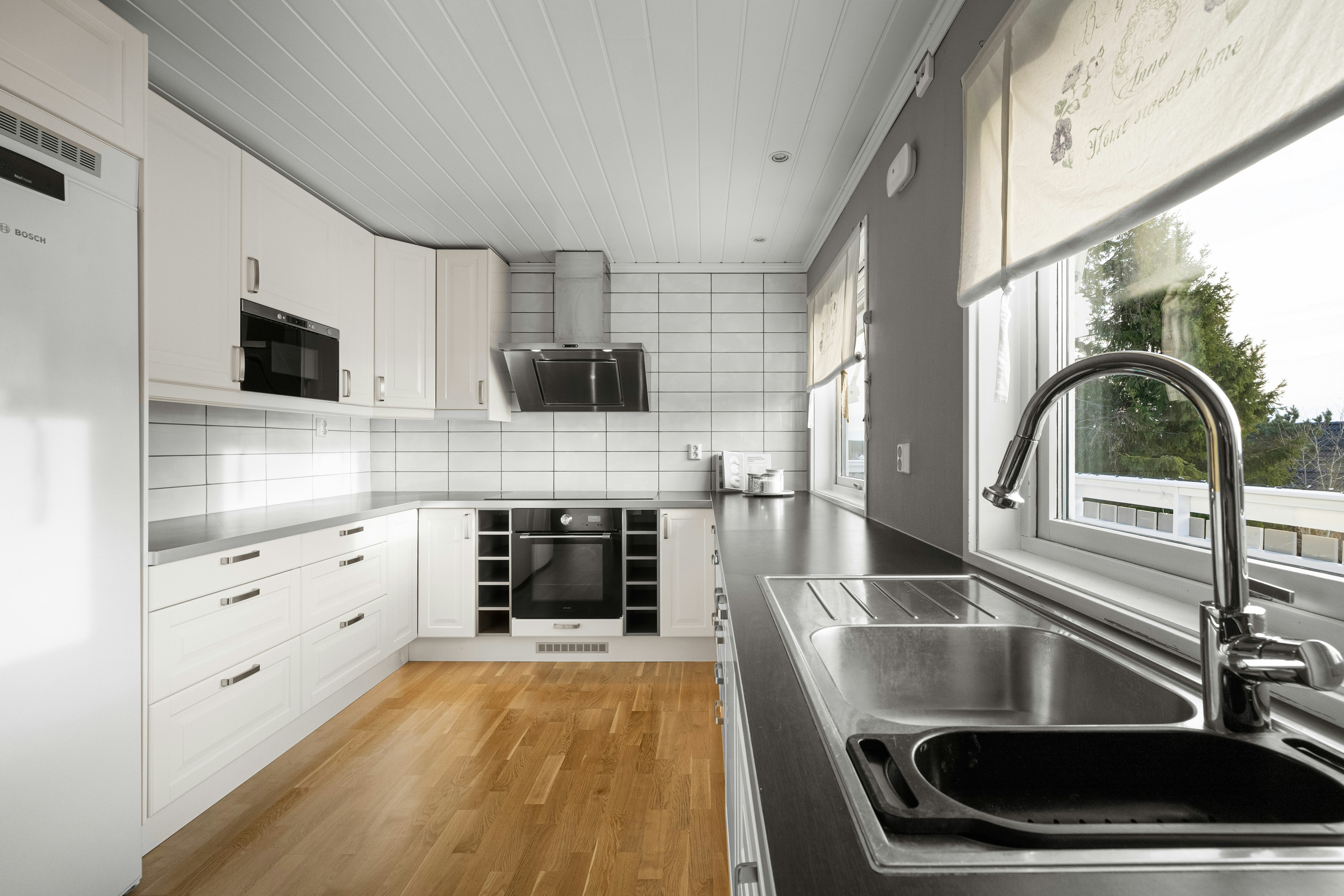 A modern kitchen featuring a sleek, stainless steel apron-front sink.