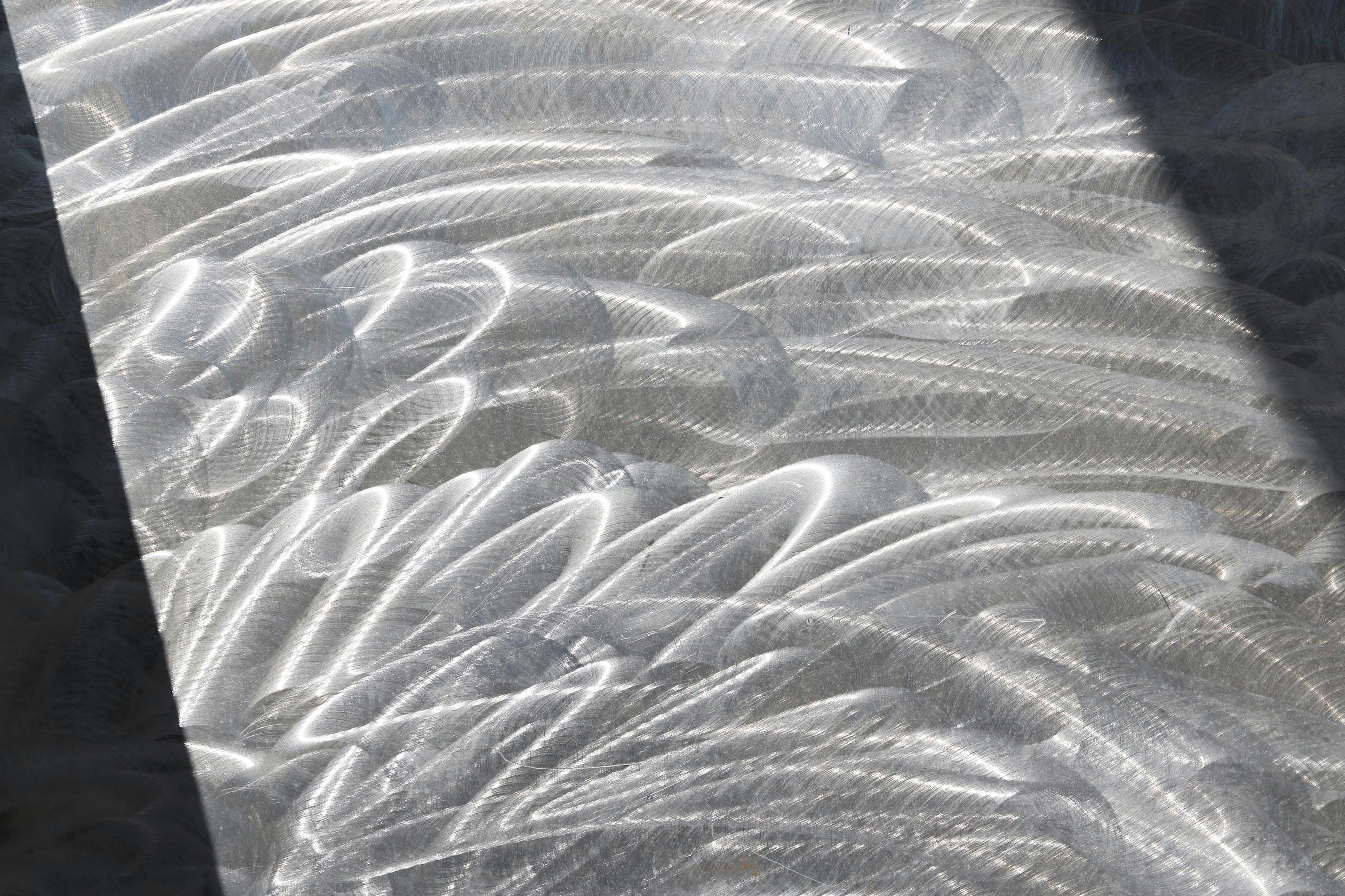 A close-up shot of a brushed stainless steel sink finish, showing the fine grain lines.