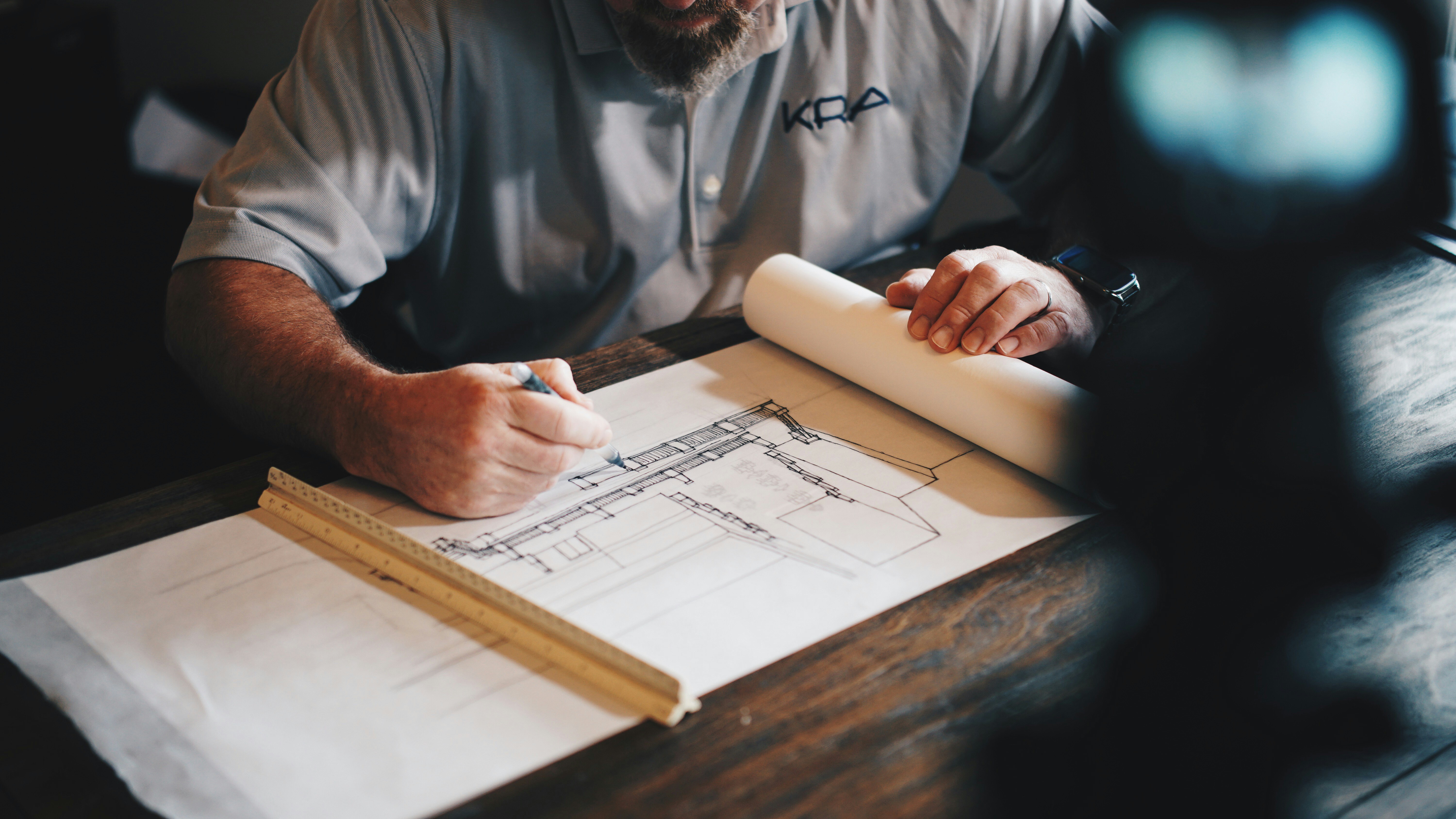 A business owner reviewing blueprints for a new bar renovation, highlighting the long-term value of a 304 stainless steel sink.