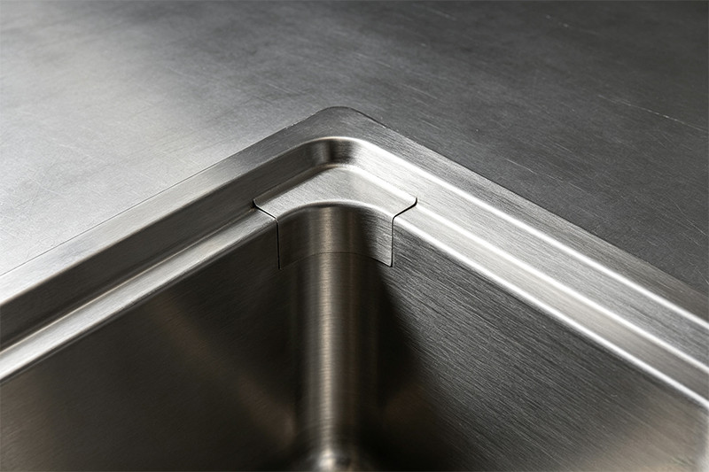 Heavy-Gauge Stainless Steel Sink in a Commercial Kitchen Image of a heavy-gauge stainless steel sink being used in a busy commercial kitchen, highlighting its durability.