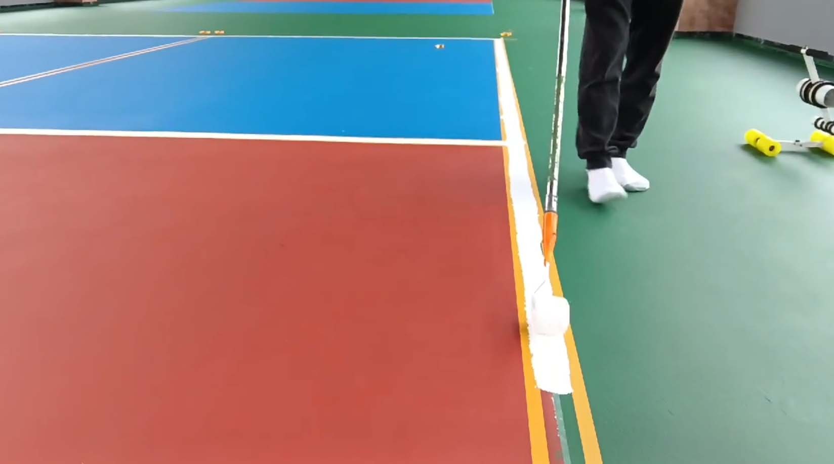 Measuring and marking pickleball court lines Person using a chalk line to mark pickleball court dimensions