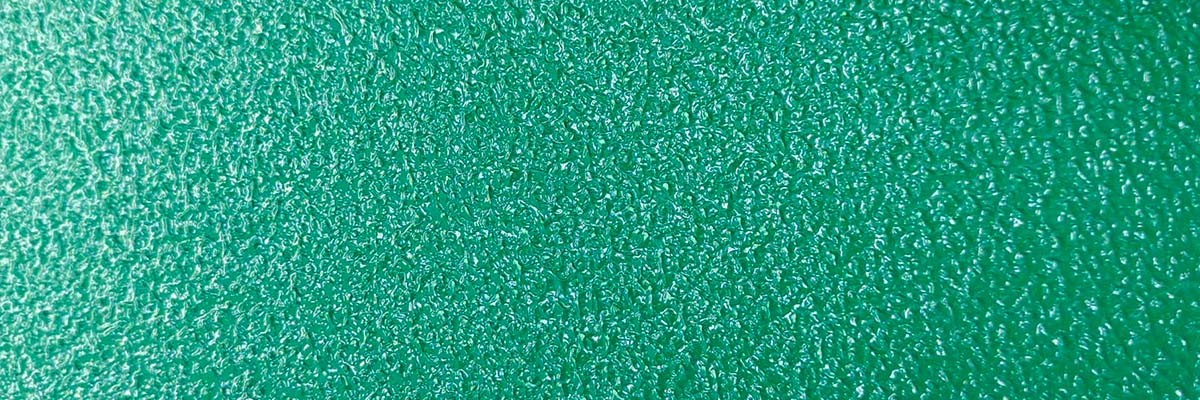 Close-up of an industrial orange peel epoxy topcoat on a parking deck floor, showing the subtle texture and sheen.