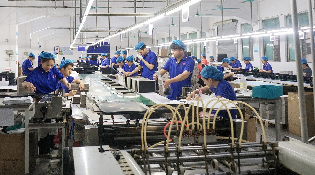 Workers assembling rigid baseball hat gift boxes in modern packaging factory