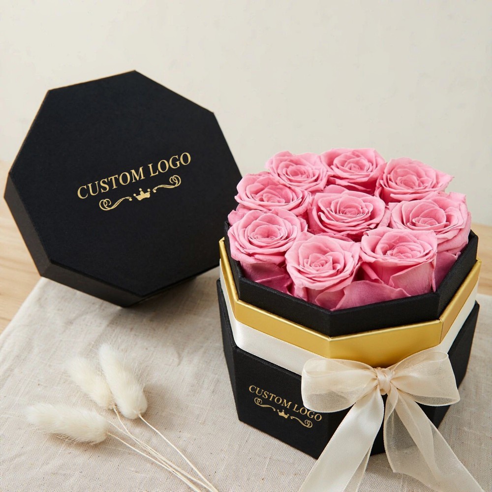 Open octagonal flower gift box with gold foil logo and pink preserved roses