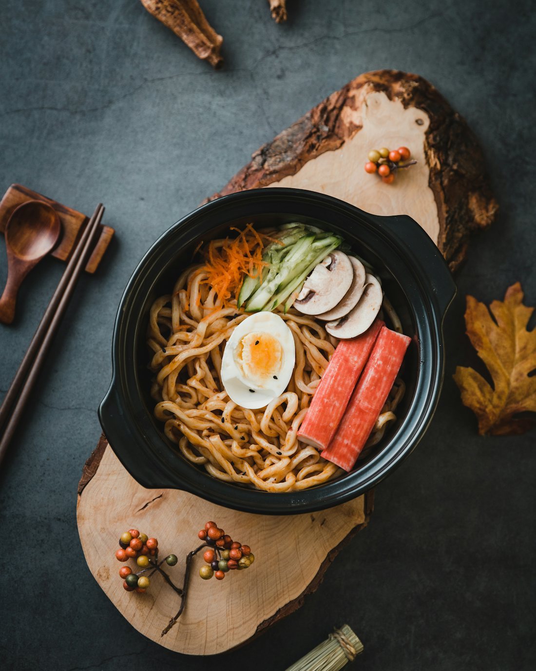 Liquid ramen soup base being prepared into finished bowls in a kitchen