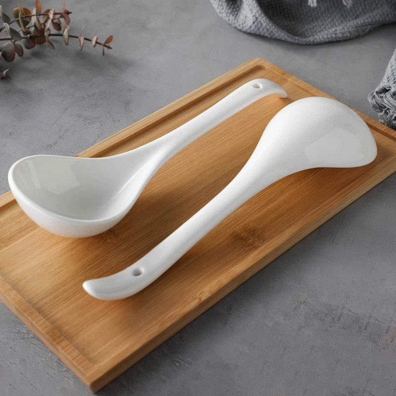 White Ceramic Spoon Displayed On Wooden Table
