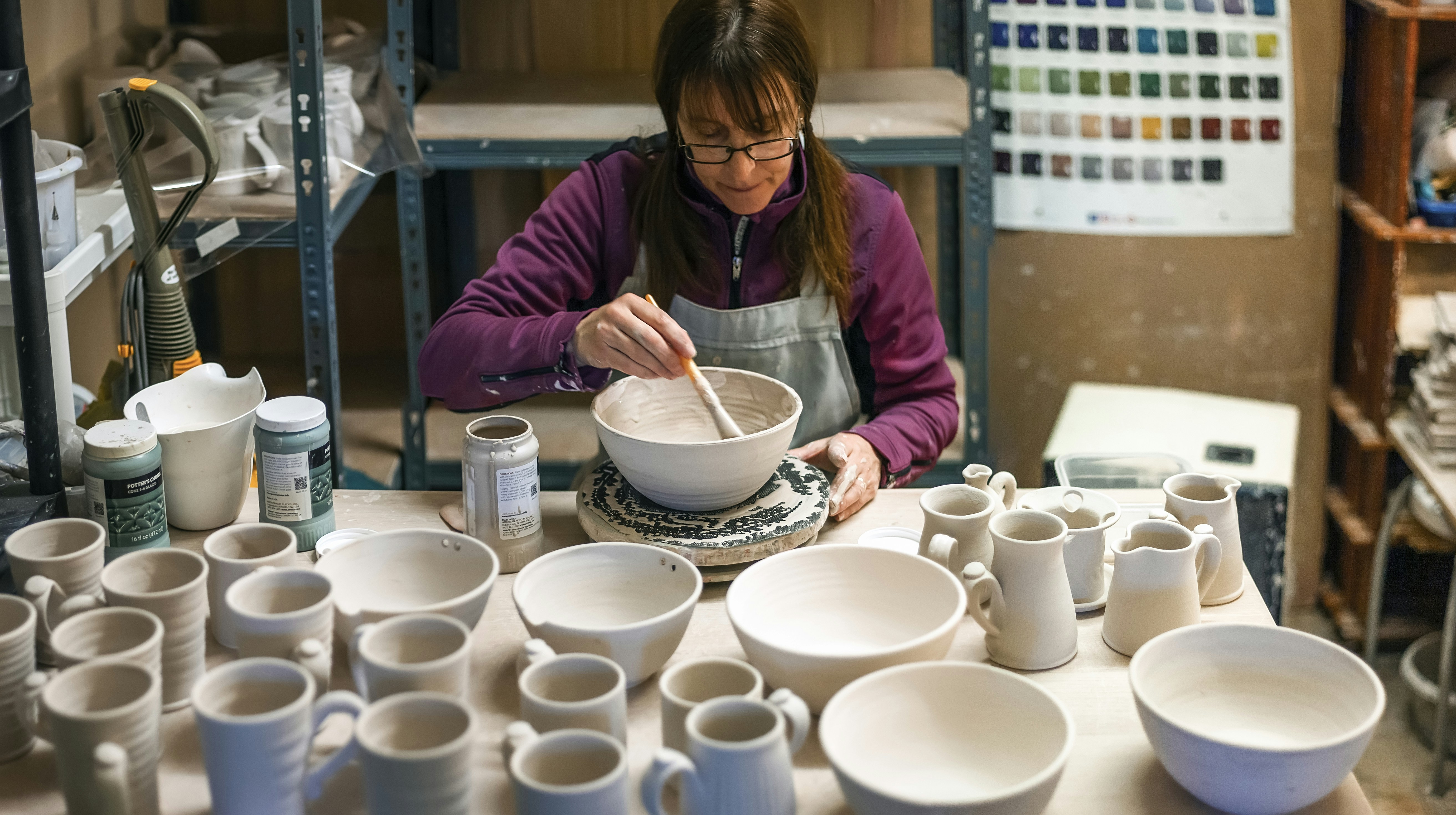A quality control expert inspects custom ceramic mugs for defects.