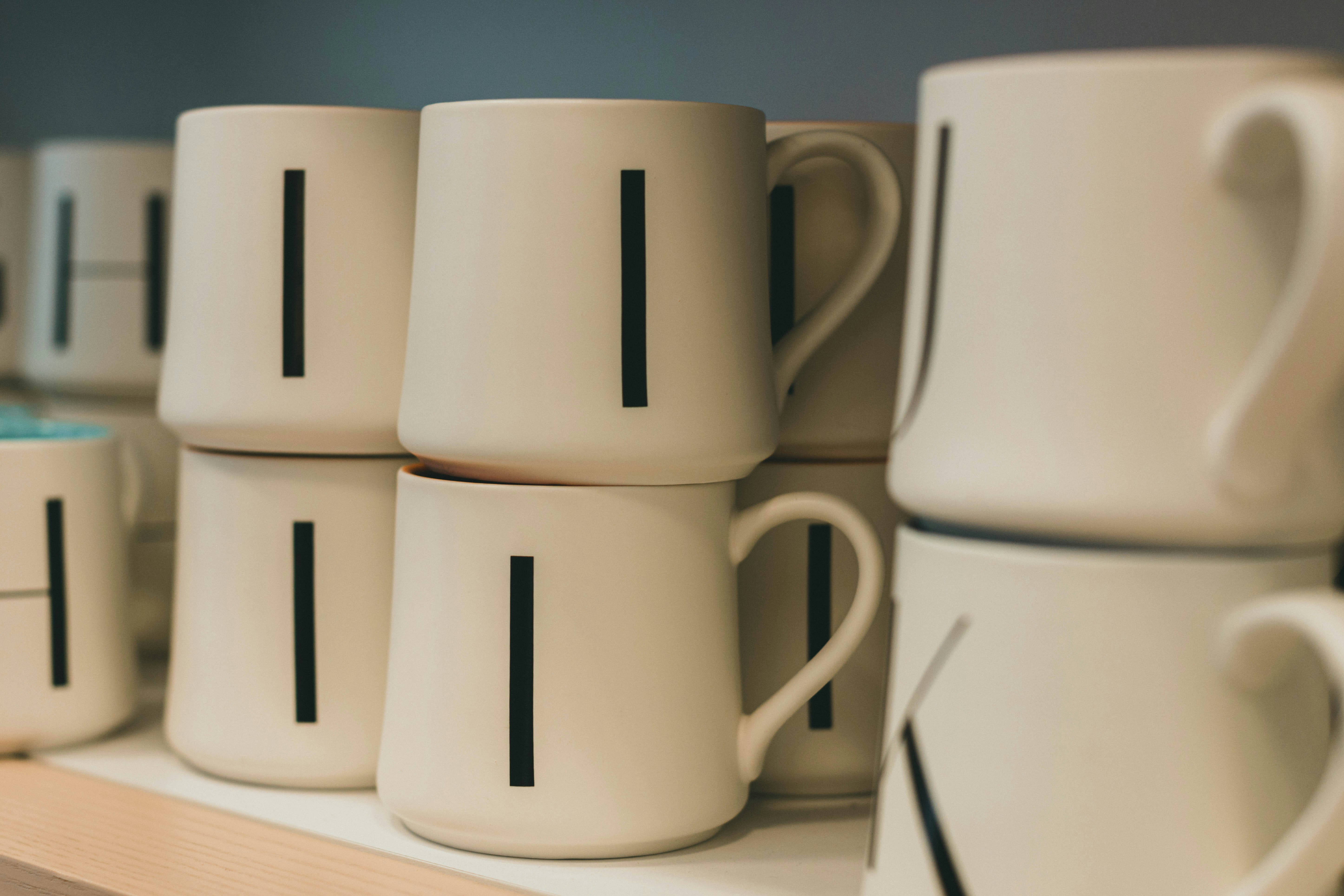 A display of various machine-made custom ceramic mugs in bulk.