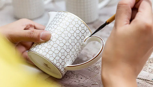Decoración manual de tazas de café en la fábrica