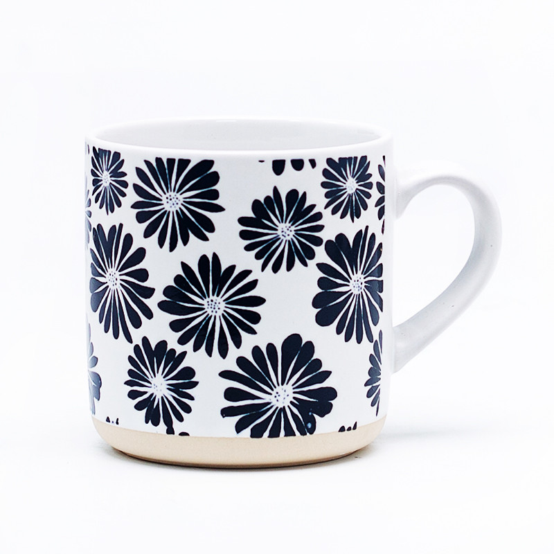 Black and white ceramic mug with navy daisy pattern front view