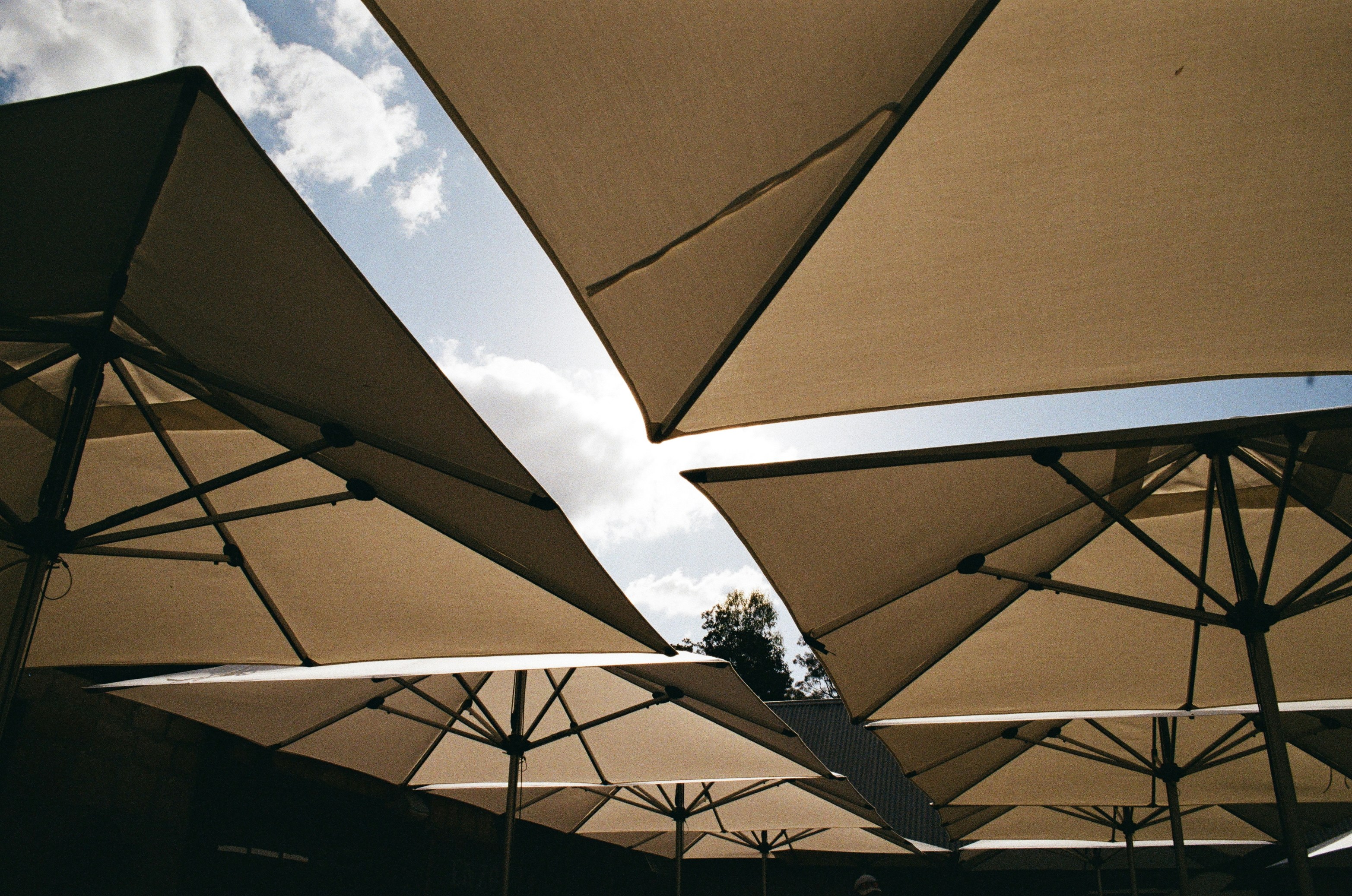 A large cantilever umbrella providing unobstructed shade over a modern patio sectional sofa