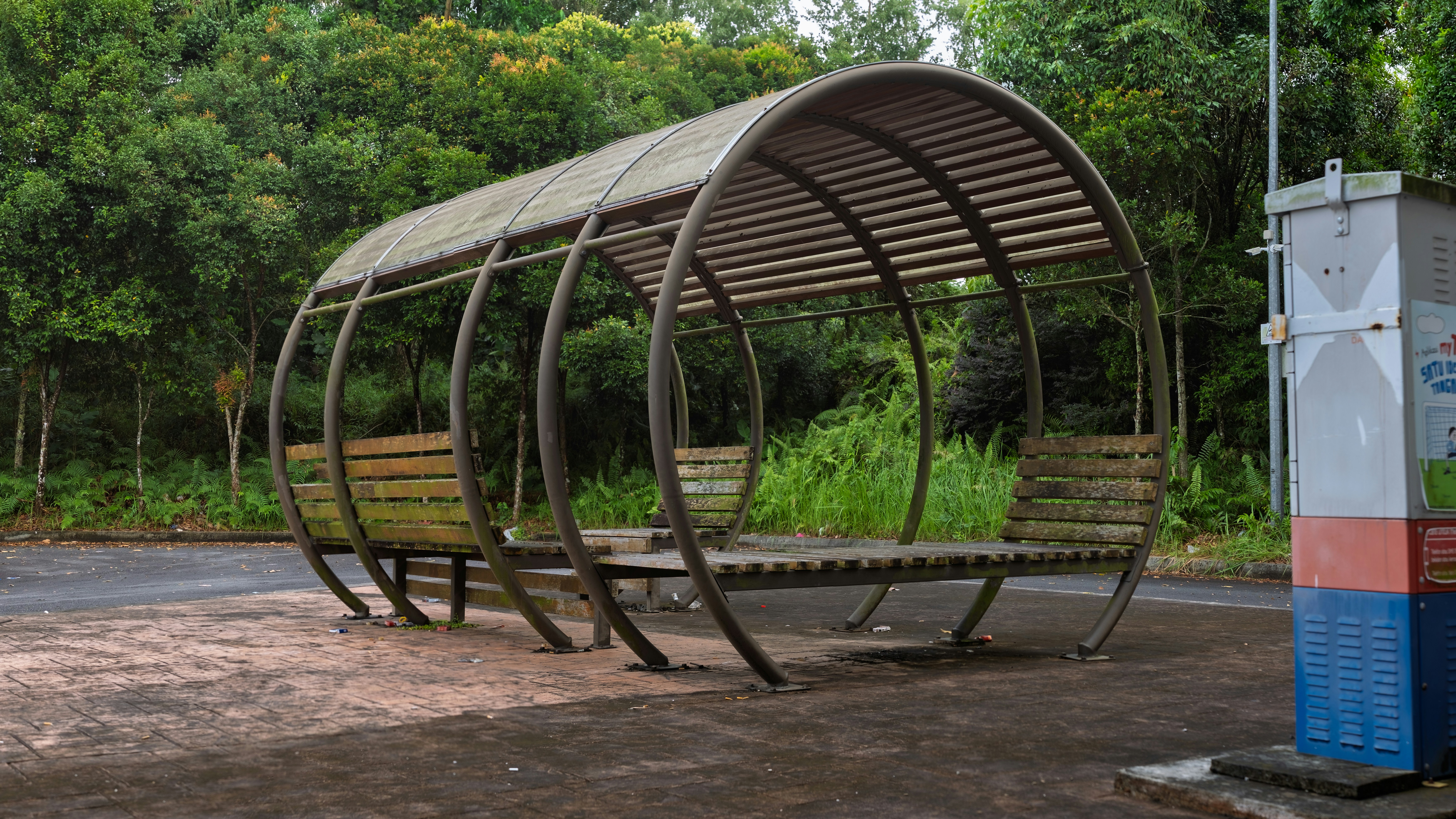 A sleek, heavy freestanding base for a cantilever umbrella next to a smaller base designed to fit under a table