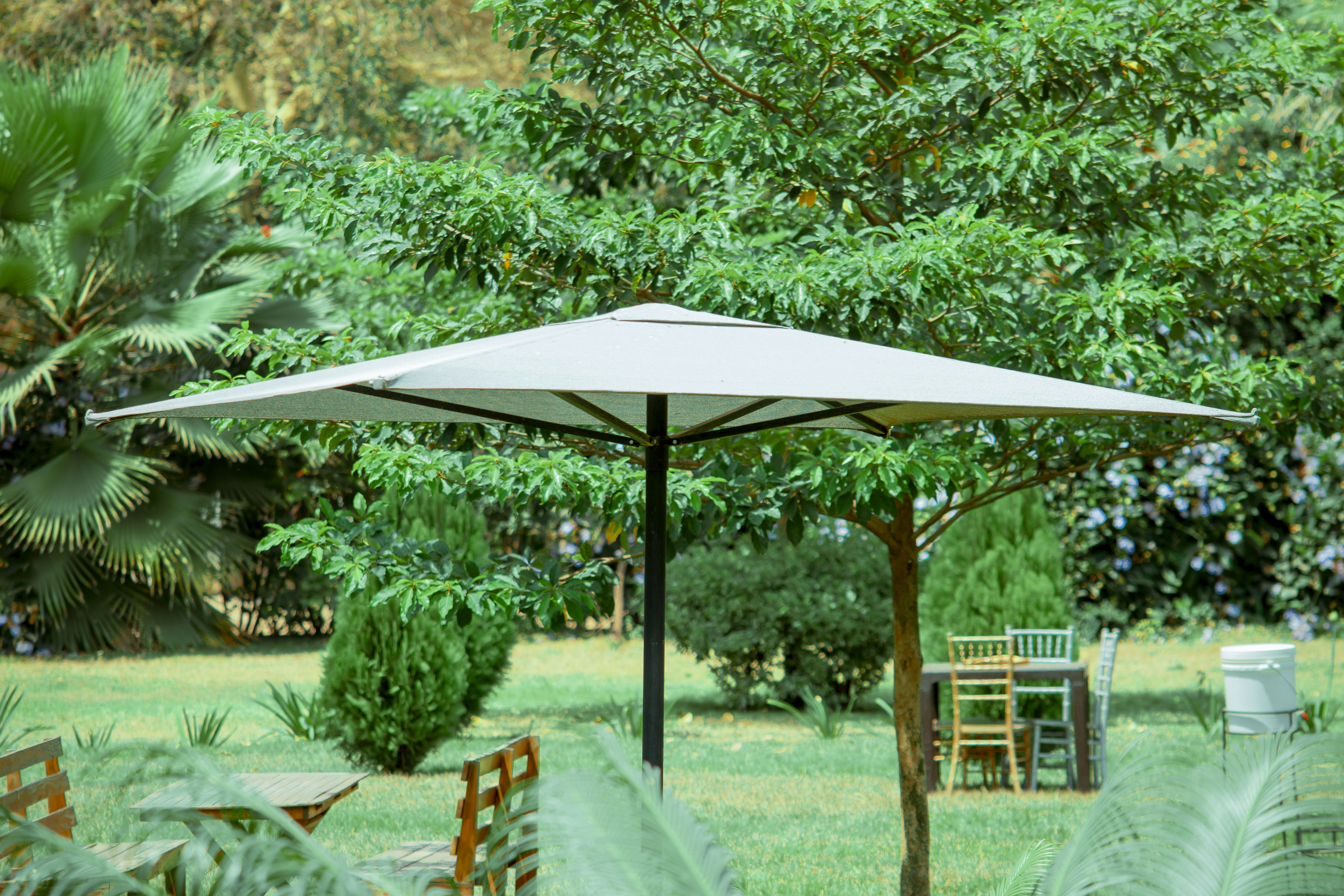 A large cantilever umbrella with an offset pole shading a comfortable outdoor lounge set.