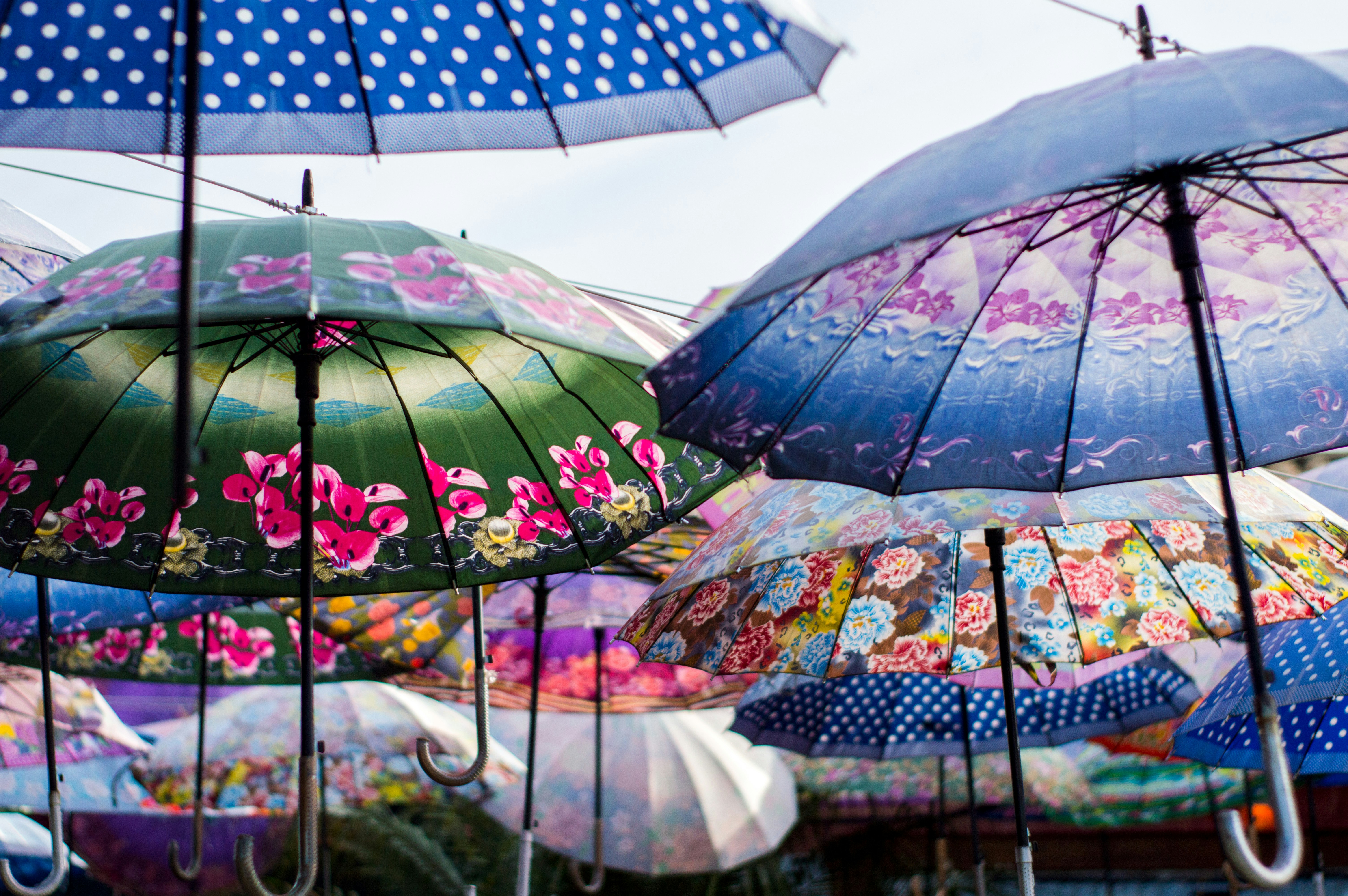 A collection of vibrant commercial umbrellas in an outdoor cafe setting.
