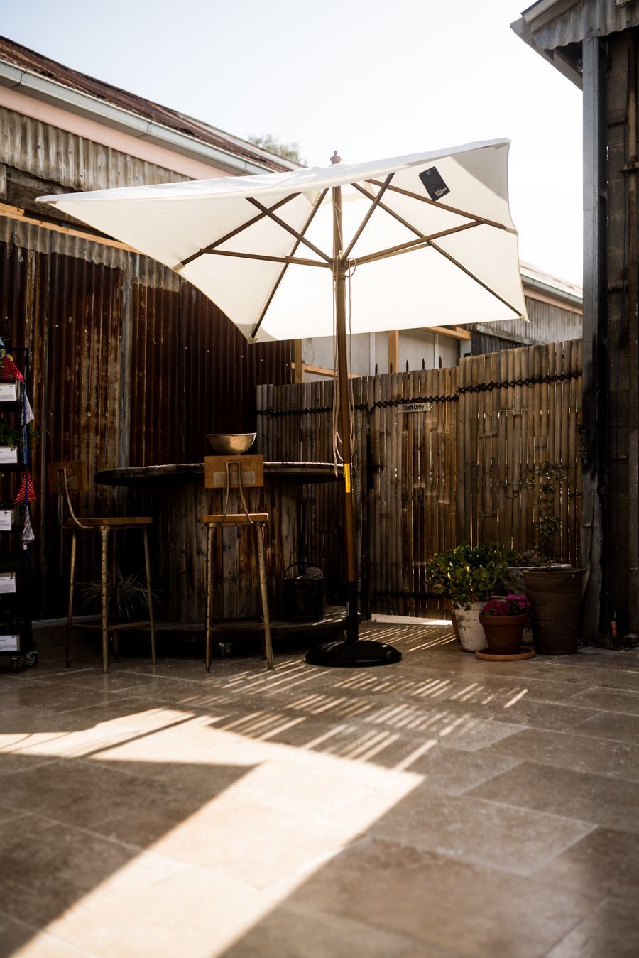 Sun-drenched terrace with a white patio umbrella and rustic decor