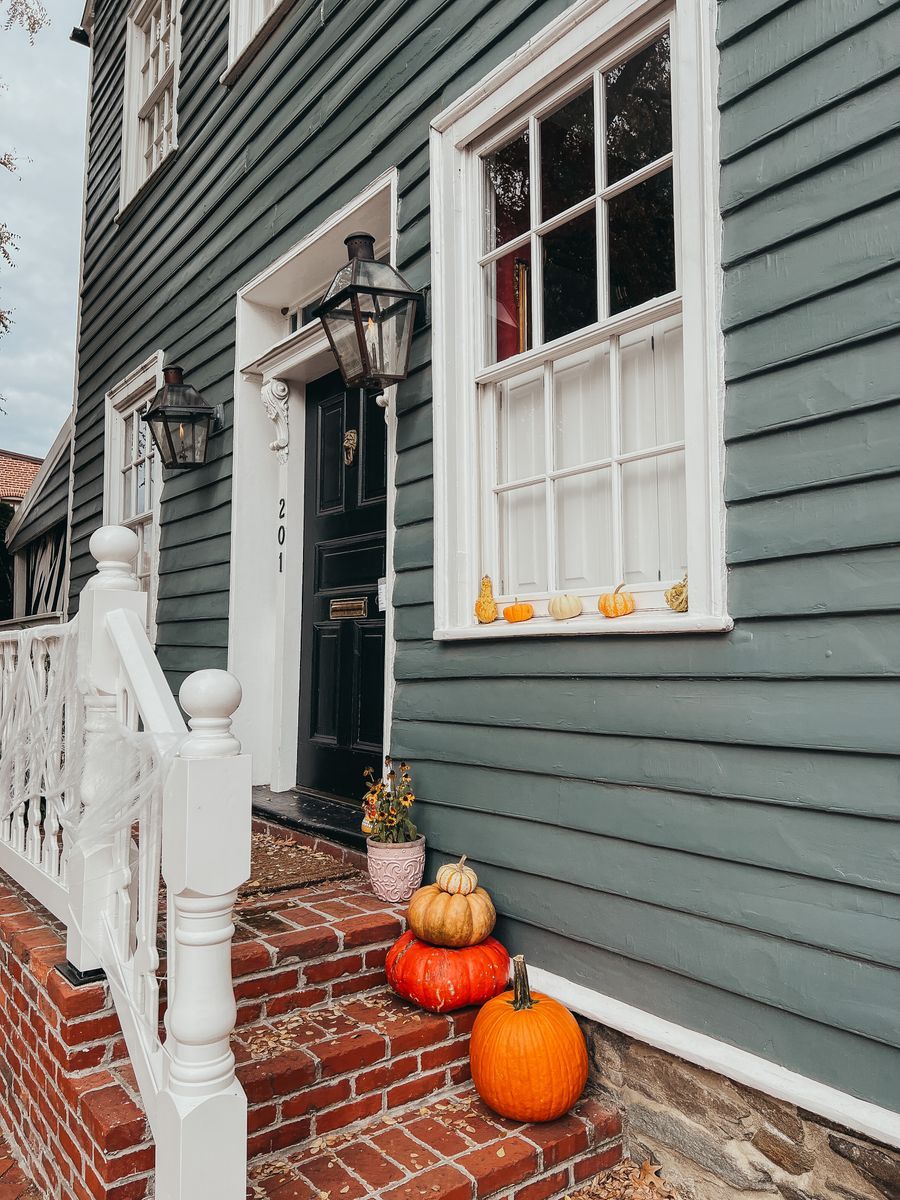 Cozy autumn porch with pumpkins, lanterns and seasonal doorway decor