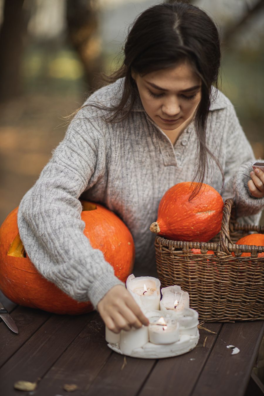 Candles arranged in pumpkins for an outdoor autumn celebration at dusk