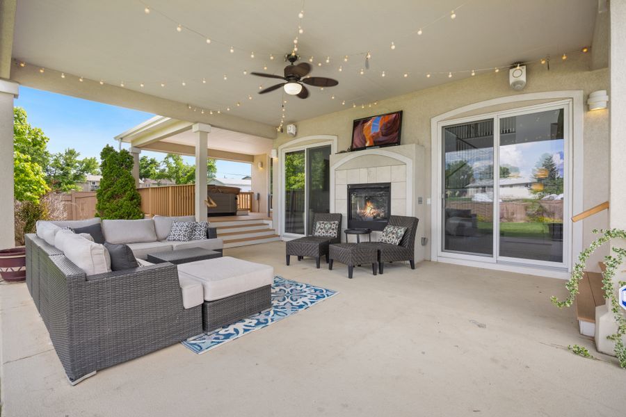 Outdoor patio with fireplace, modern furniture and ambient string lights