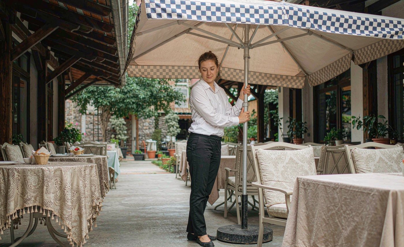 A staff member opening a patio umbrella with minimal effort