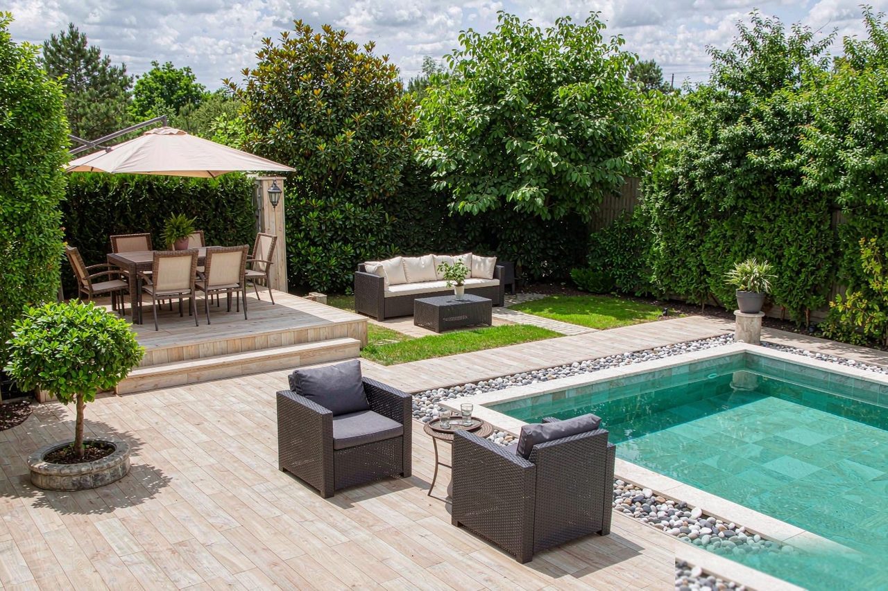 Example of a garden split into dining, lounge and poolside zones with coordinated outdoor furniture