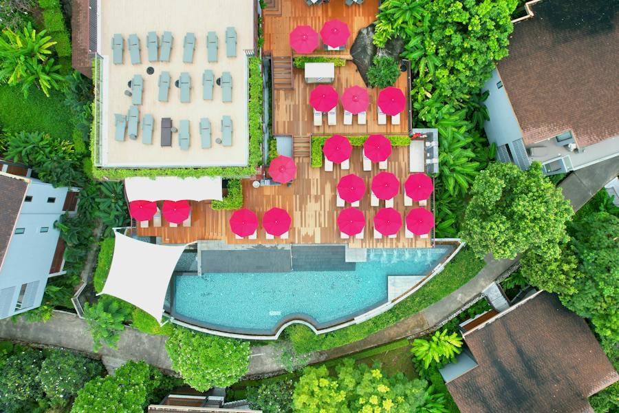 Aerial view of a resort pool deck with a grid of matching umbrellas over tables