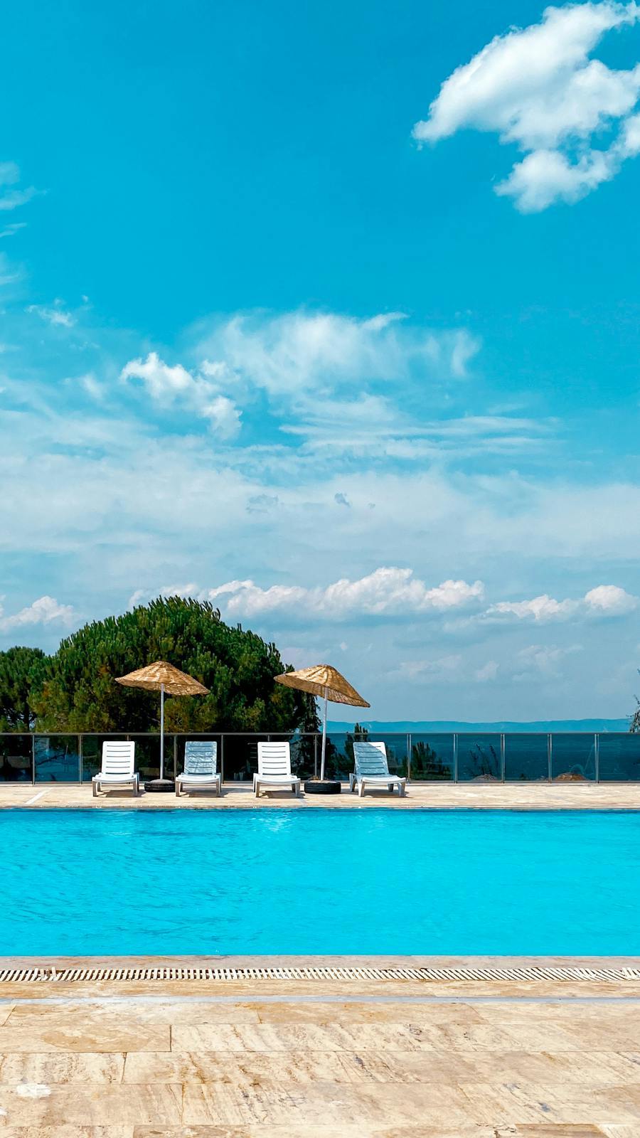 Poolside parasols with their bases resting on a paved deck