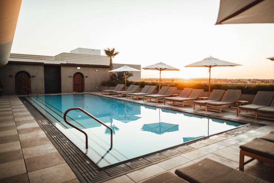 Hotel pool deck at sunrise with umbrellas standing on the paving