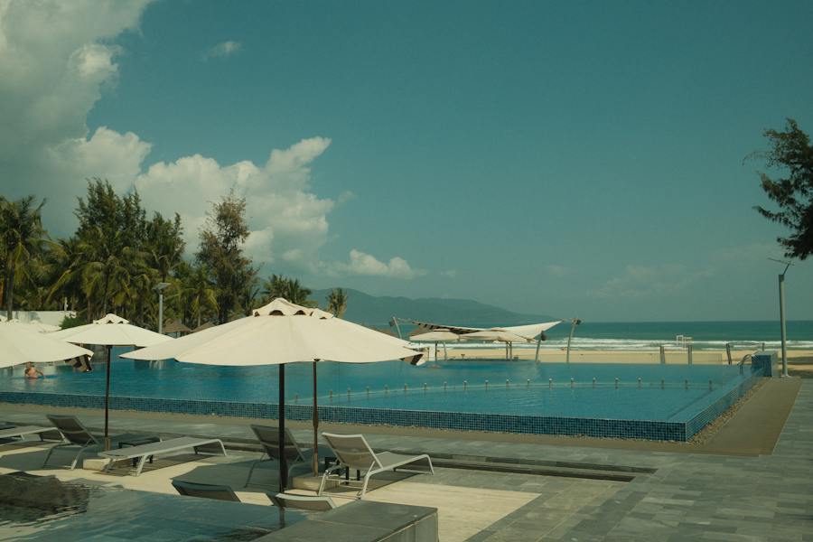 Beachfront resort pool with freestanding umbrellas on the deck