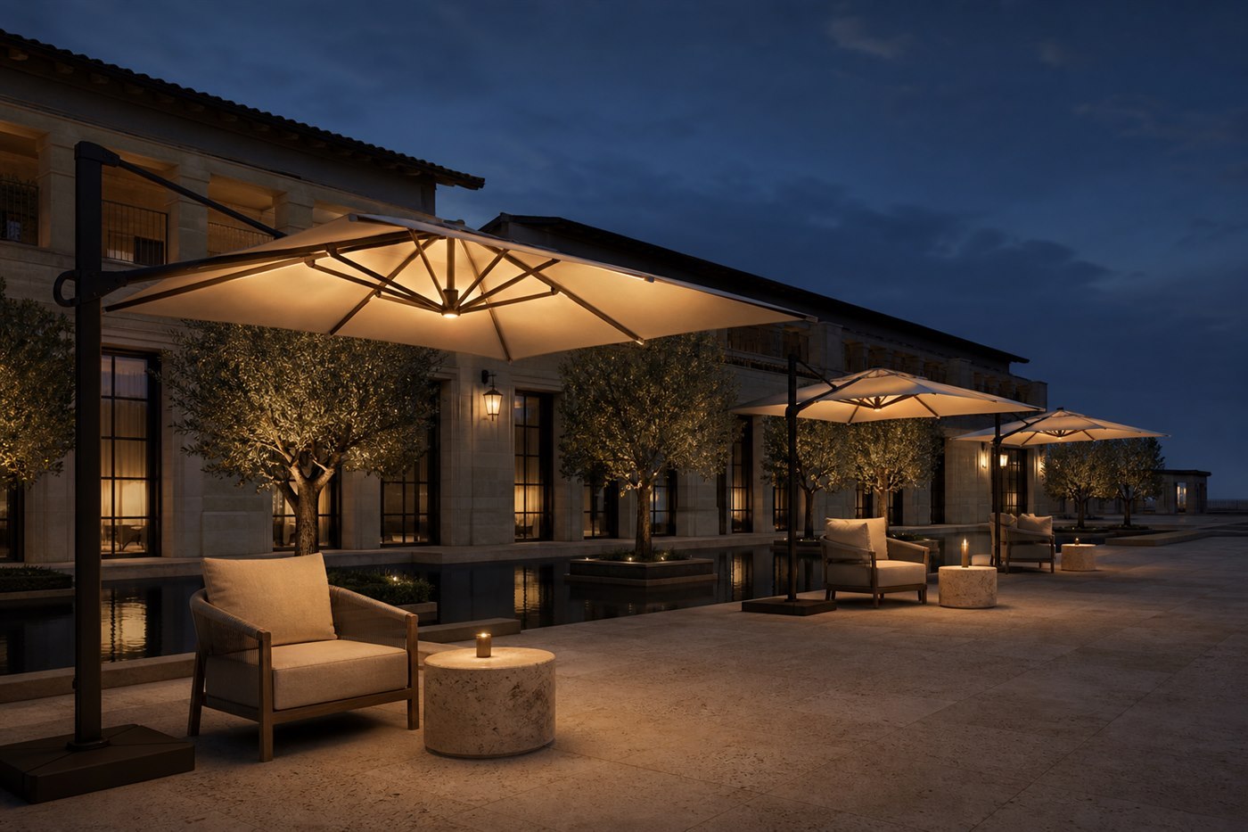 Row of lit cantilever umbrellas over a hotel courtyard terrace at dusk