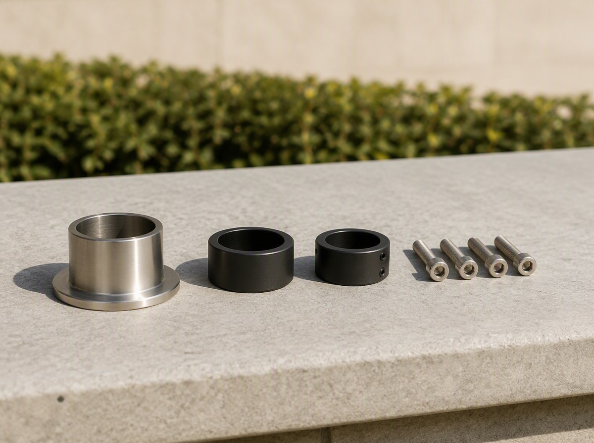 Reduction collar, pole adaptor rings and stainless fixing bolts arranged on a pale stone surface