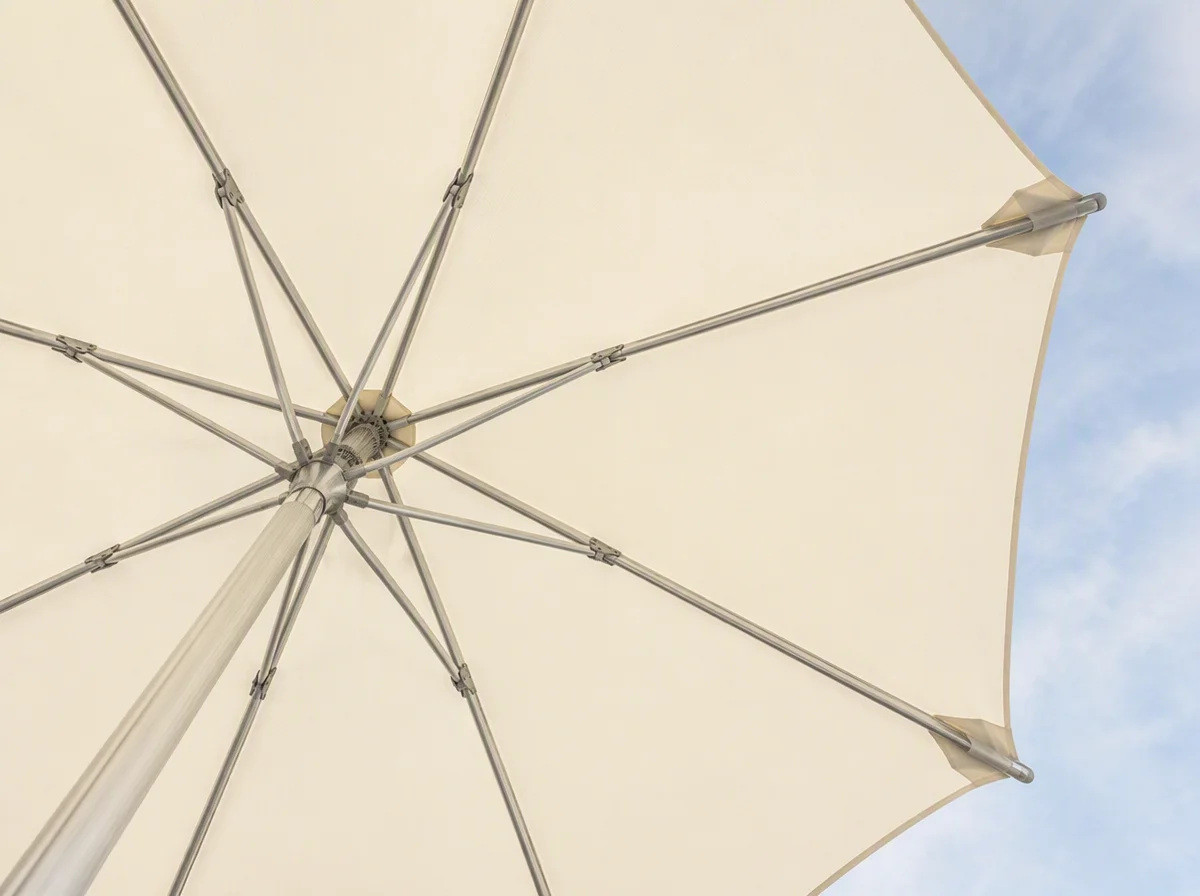 View from underneath a large open umbrella showing the aluminium ribs radiating from the hub