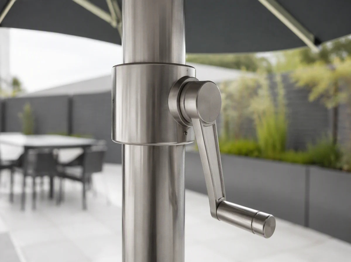 Close view of the brushed stainless crank handle and collar on a commercial umbrella pole