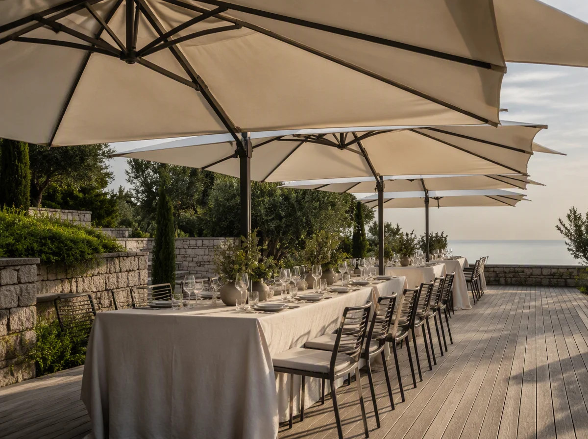 Event terrace set with long tables under a row of large commercial umbrellas
