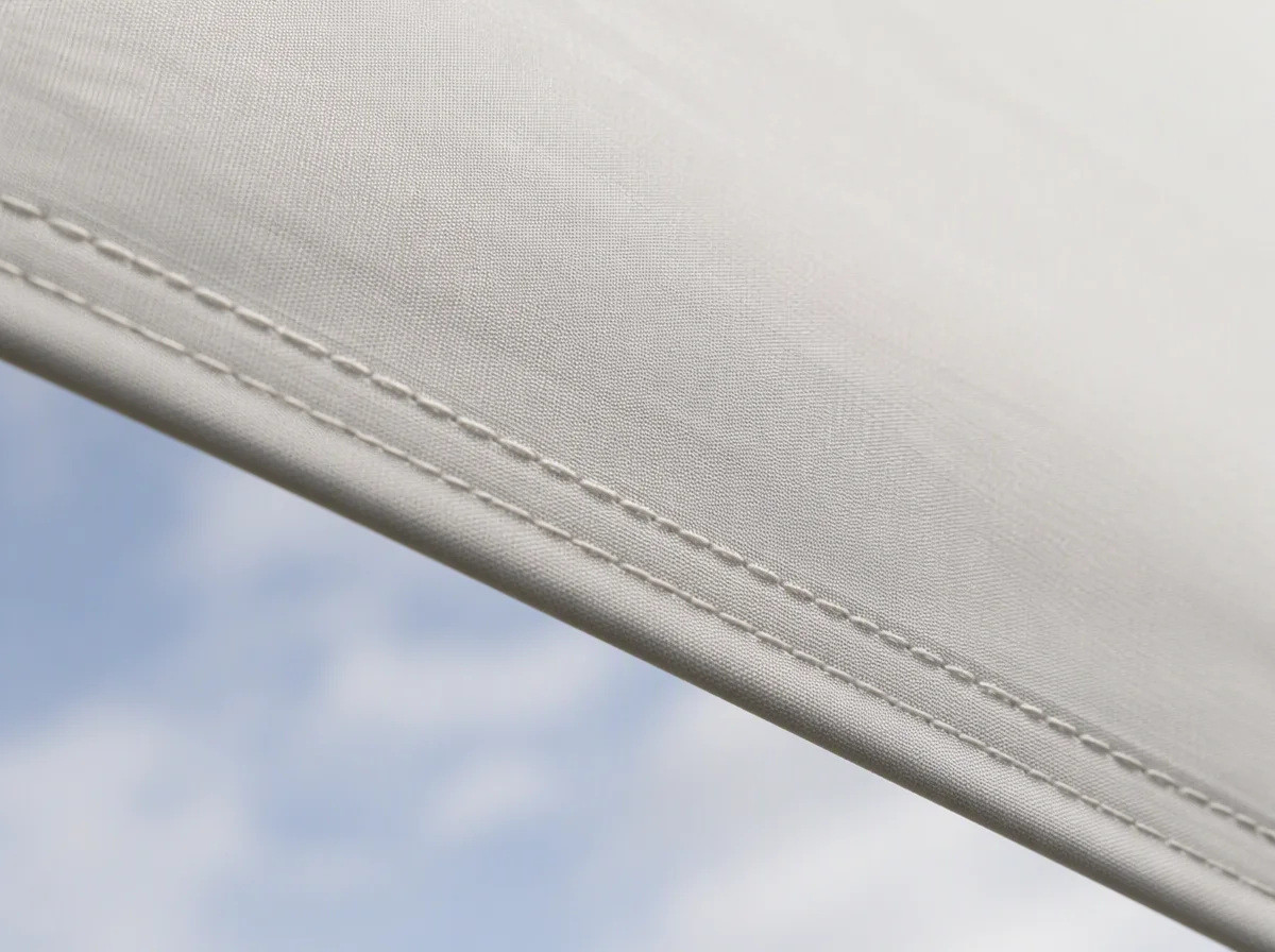 Close view of heavyweight outdoor canopy fabric showing the tight weave and a double stitched hem