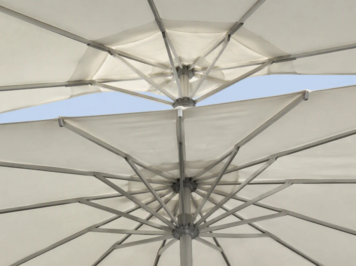 View from underneath a double-tier umbrella canopy showing the gap between the main and upper tiers