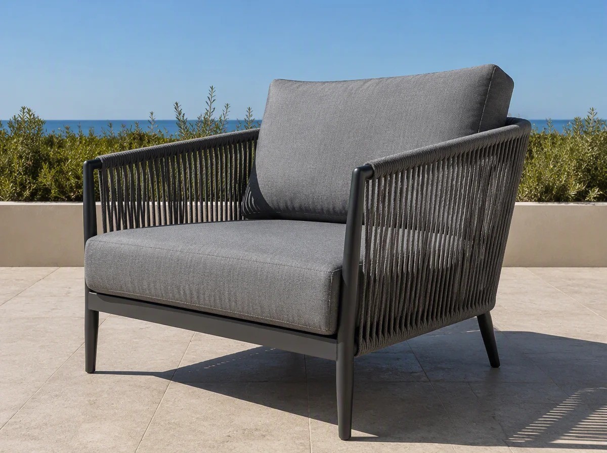 Rope weave lounge armchair with a charcoal frame and a grey cushion on a stone terrace