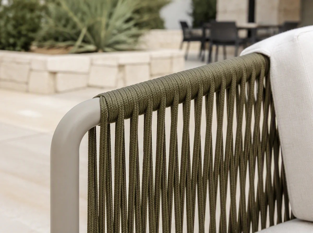 Close view of olive-green rope woven in vertical lines over a cream aluminium arm panel