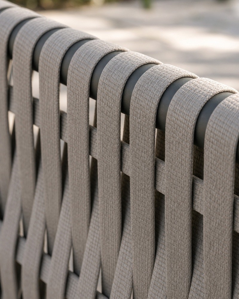 Light grey rope weave wrapped around the dark grey aluminium frame of the outdoor sofa