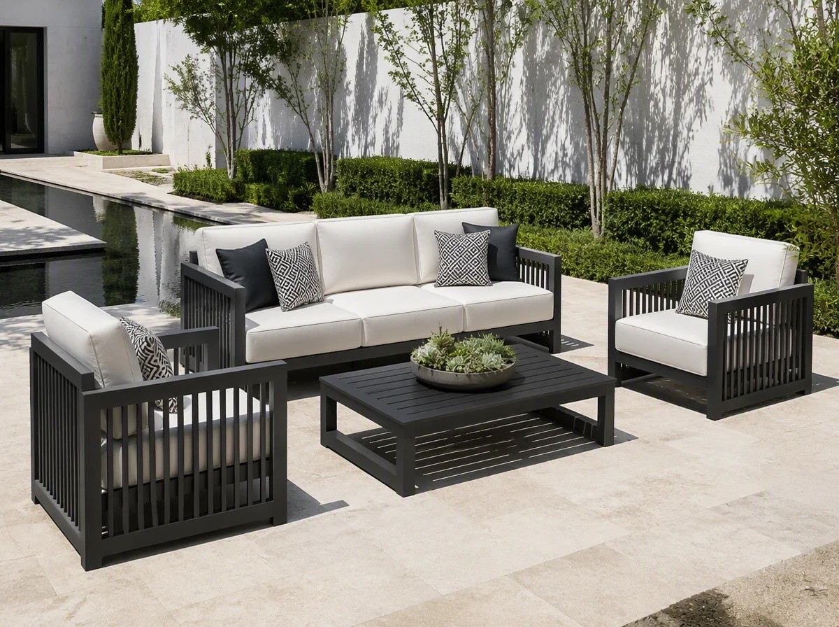Charcoal aluminium outdoor sofa set beside a reflecting water feature in a modern villa courtyard