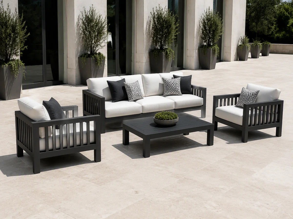 Charcoal aluminium outdoor sofa set on a wide hotel terrace of pale travertine