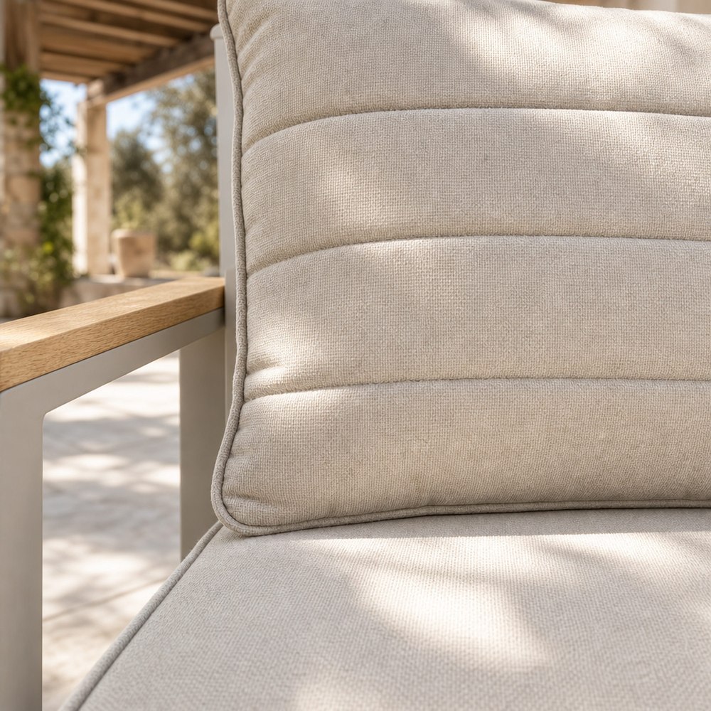 Cream cushion with horizontal quilting and piped edging on the aluminium outdoor sofa