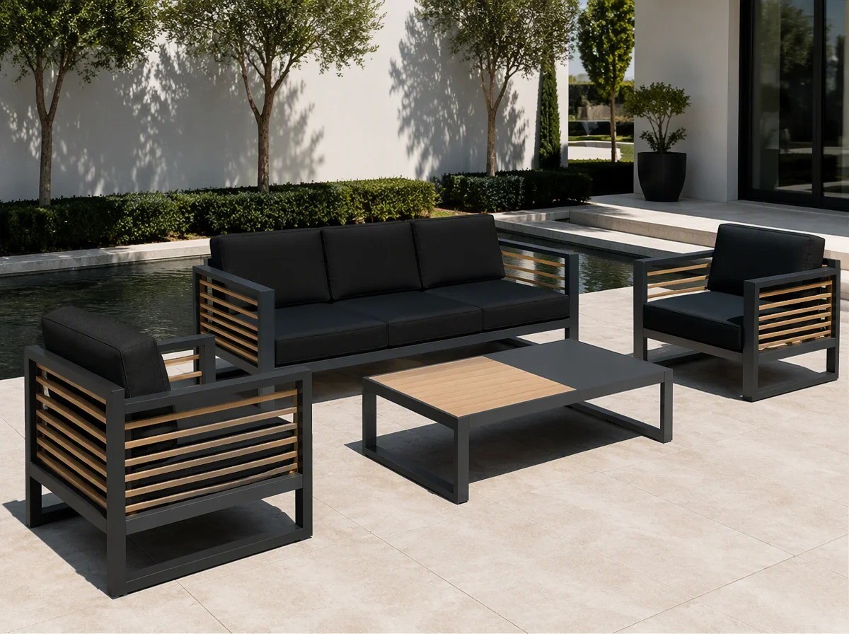 Charcoal aluminium outdoor sofa set with wood-slat panels and dark grey cushions beside a reflecting water feature in a modern villa courtyard