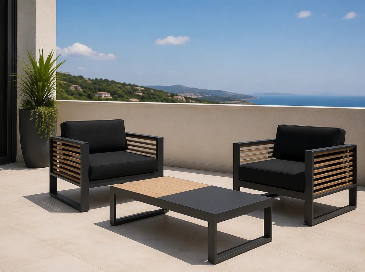 Two charcoal aluminium lounge armchairs with wood-slat backs and a low table on a hotel suite balcony