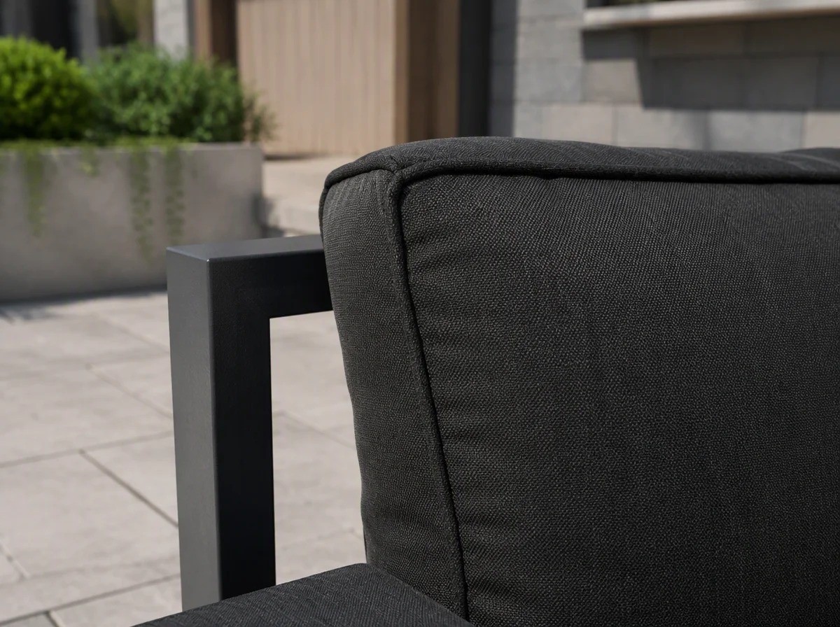 Close view of a thick dark charcoal-grey outdoor seat and back cushion with a piped edge against a charcoal aluminium frame