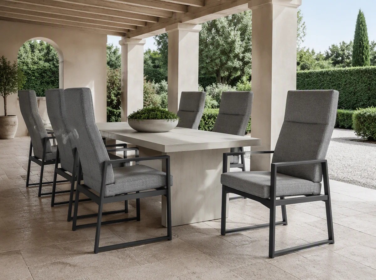 Six grey upholstered outdoor dining armchairs around a long table under a timber ceiling loggia